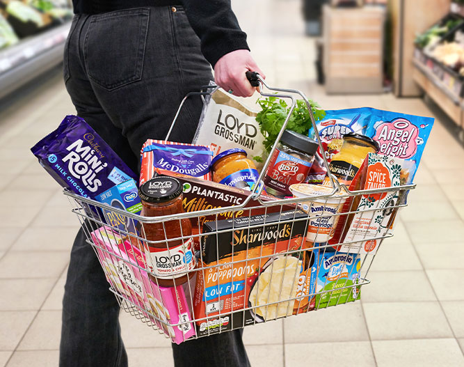 Basket with Premier Food brands in it carried by a person